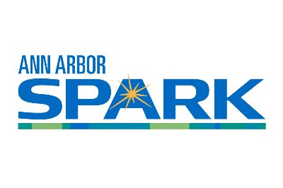 Logo with blue text 'ANN ARBOR SPARK' featuring a yellow spark symbol inside the letter A and a multicolored horizontal line below.