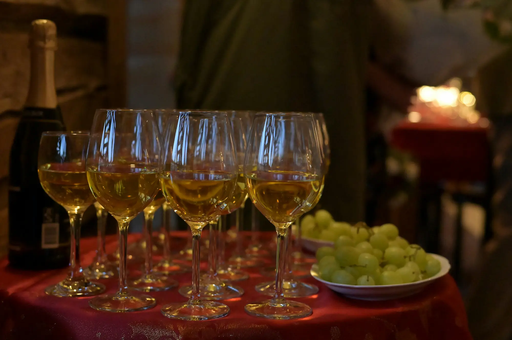 A table set with two wine glasses and a cluster of fresh grapes, creating an inviting atmosphere for a gathering.