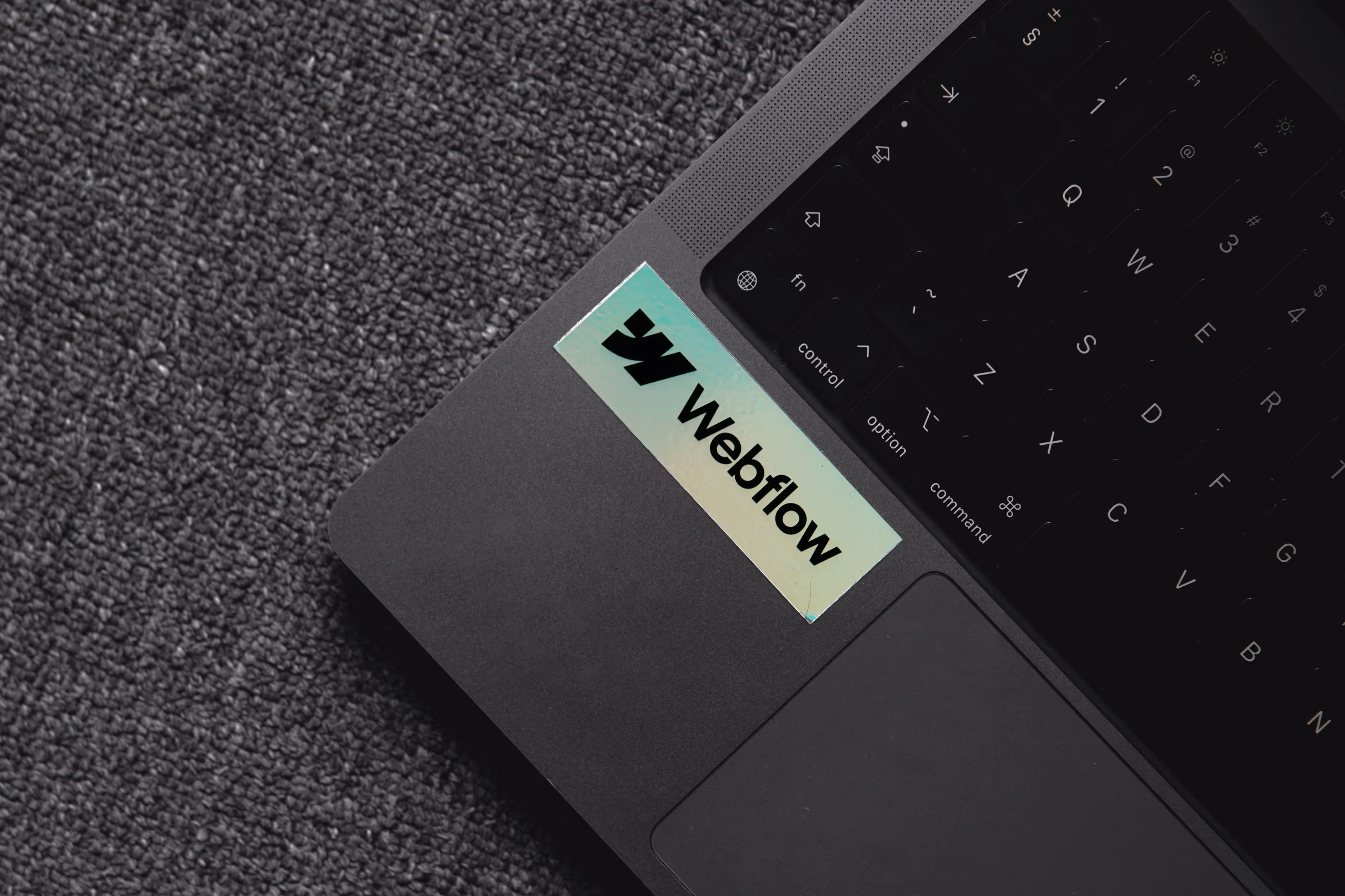 Ordinateur portable avec autocollant Webflow, symbolisant l’usage quotidien de la plateforme par freelances et entreprises.