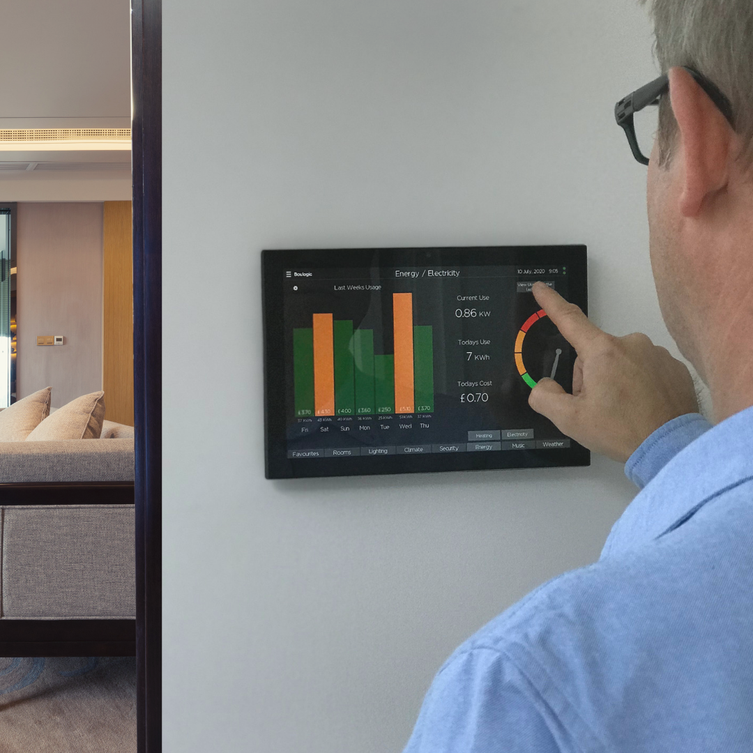 A resident checking the wall-mounted Baulogic panel — a week of energy usage and live consumption on screen.