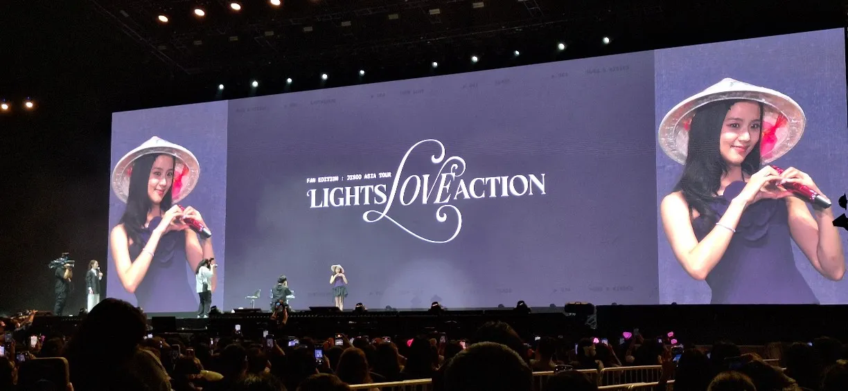Jisoo wears a traditional Vietnamese hat and forms a heart on stage during her Lights Love Action fan tour in Vietnam.