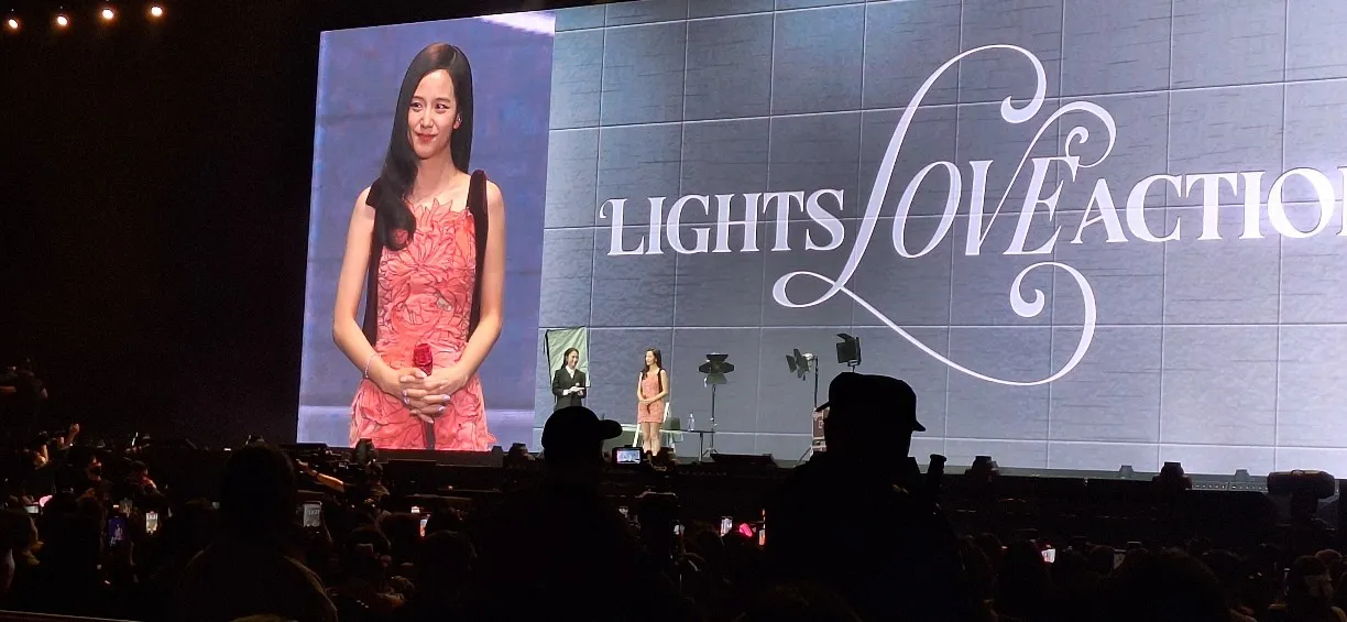 Jisoo smiling on stage in a coral dress during the Lights Love Action fan event in Vietnam.