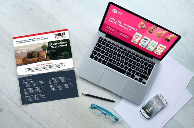 A Laptop, Brochure, And Phone On The Table