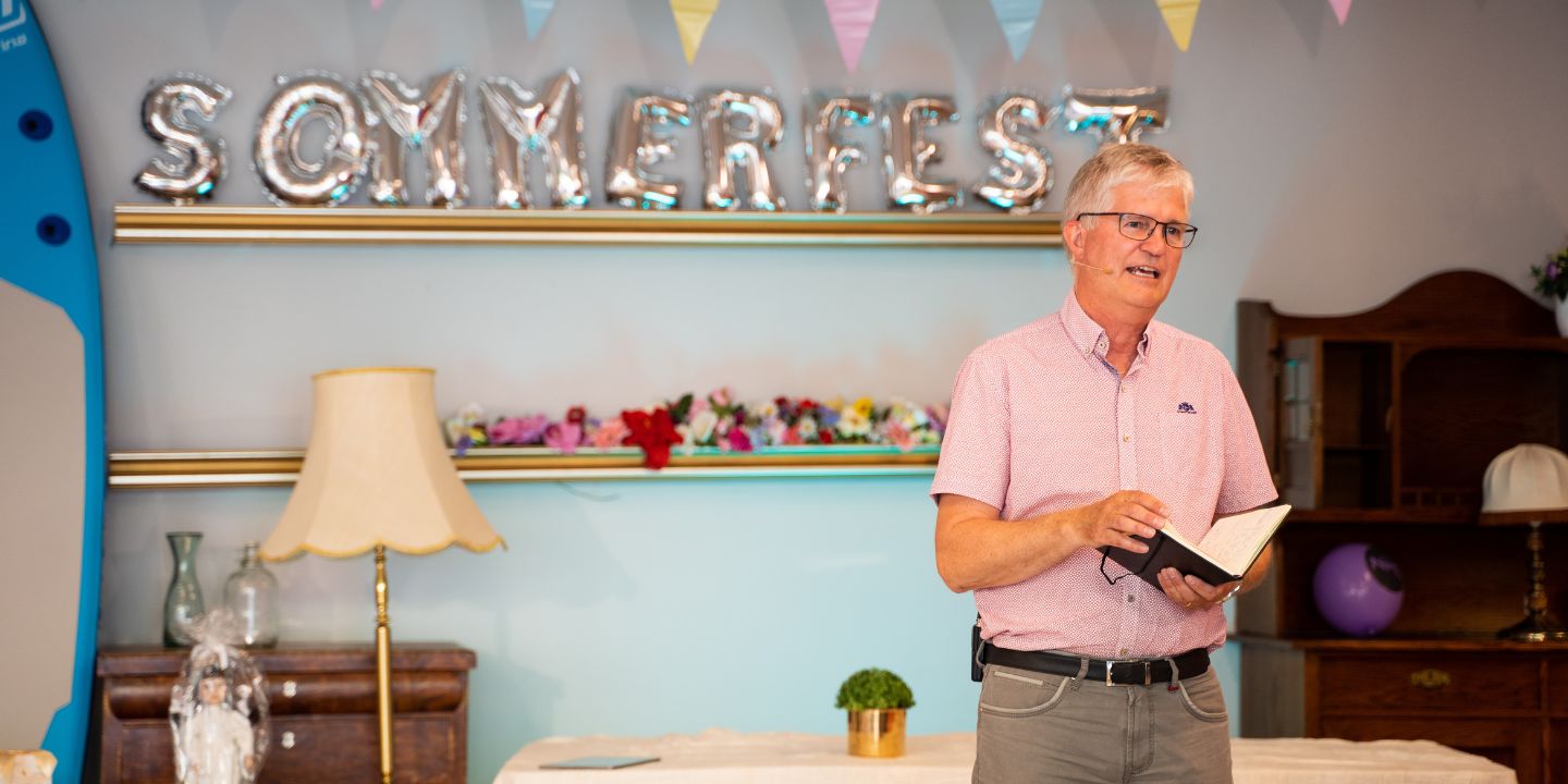 Helge S. Gaard foran ballonger som former ordet Sommerfest