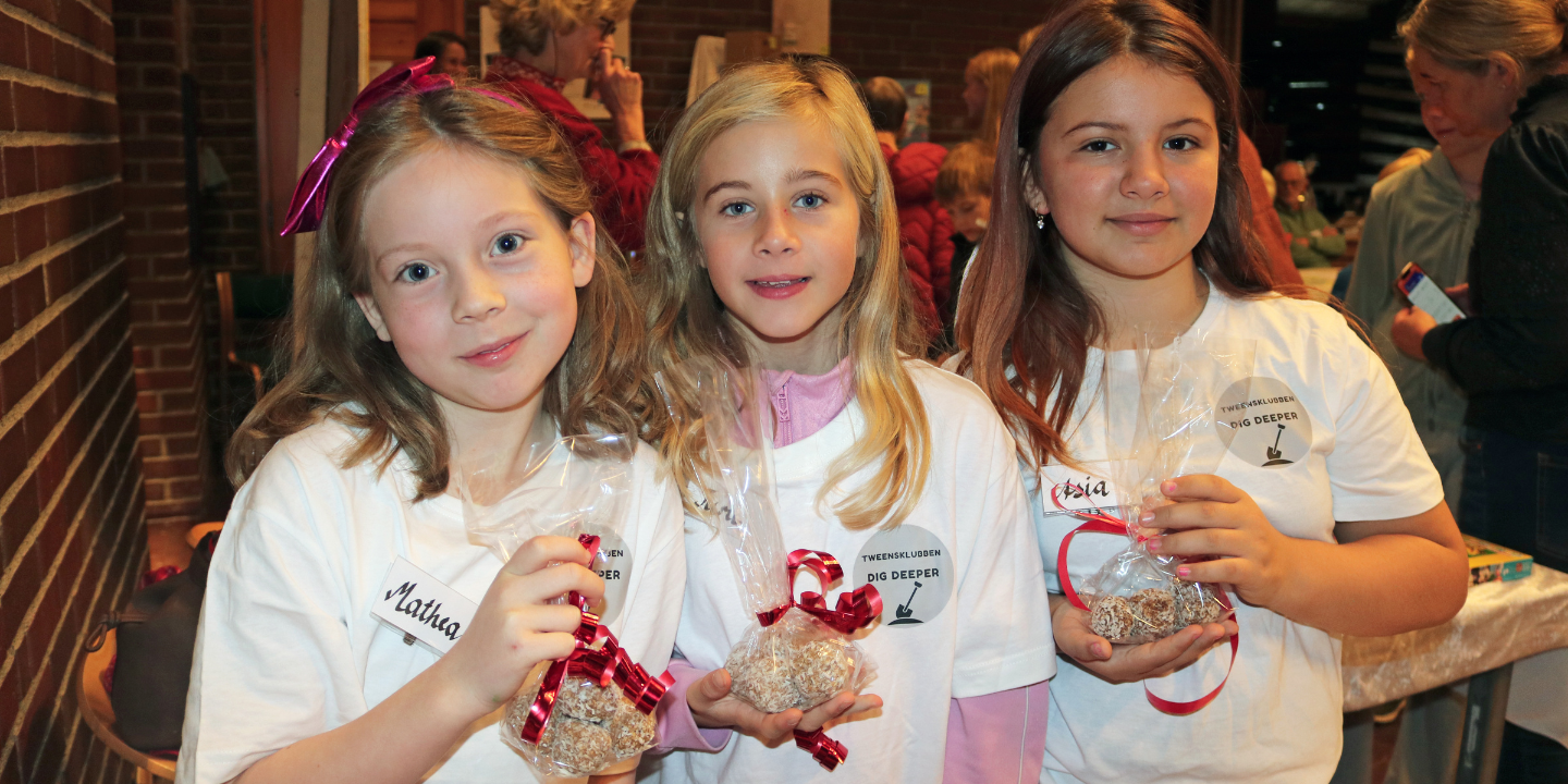 Tre jenter holder fram egenlagde salgsprodukter