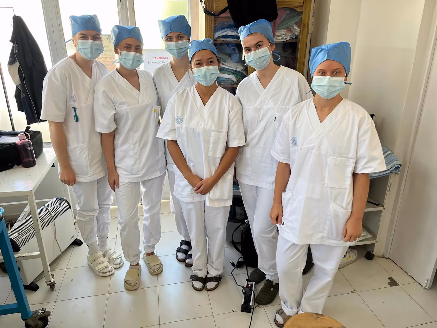 Bildet viser seks studenter med munnbind, arbeidsklær og hodeplagg