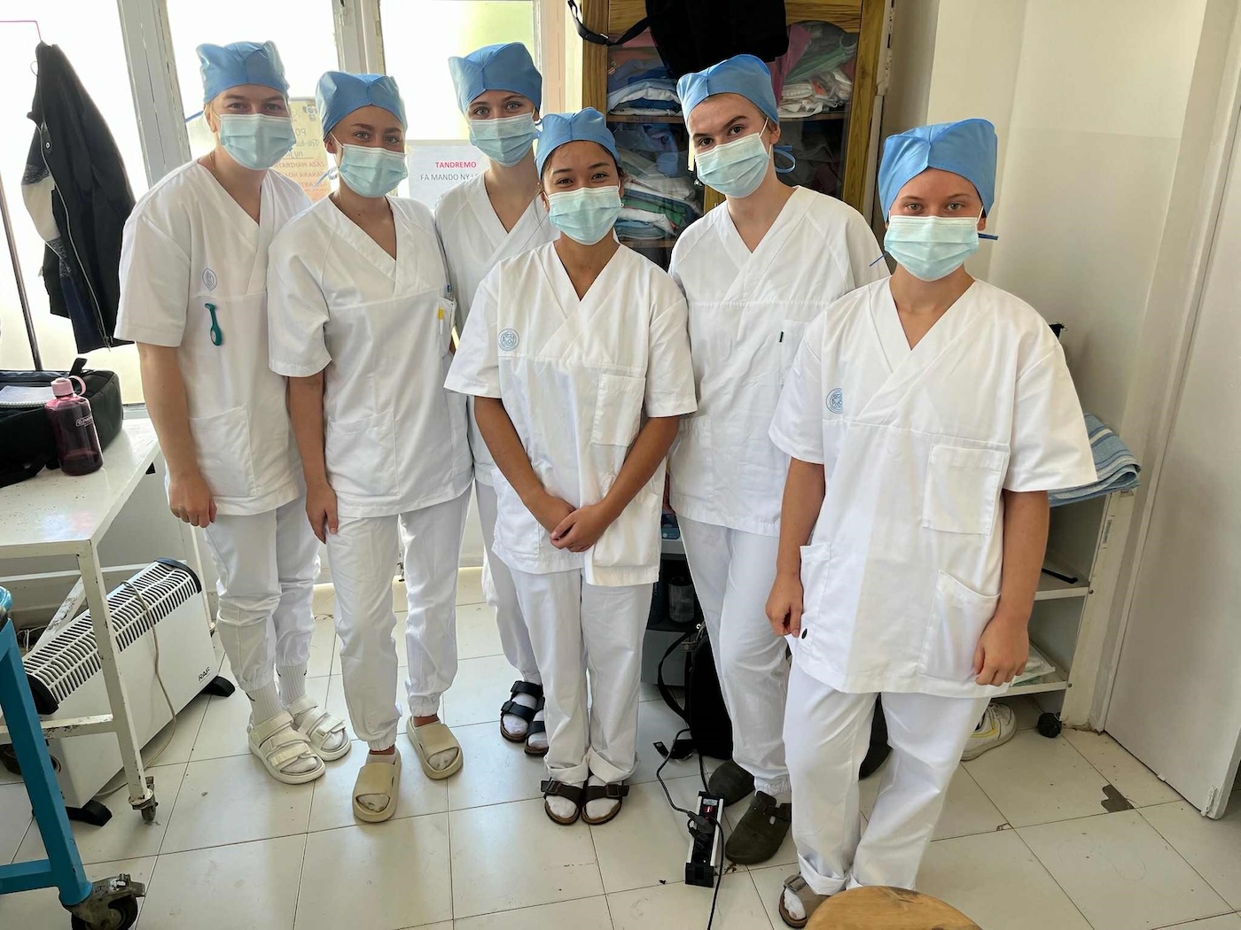 Bildet viser seks studenter med munnbind, arbeidsklær og hodeplagg