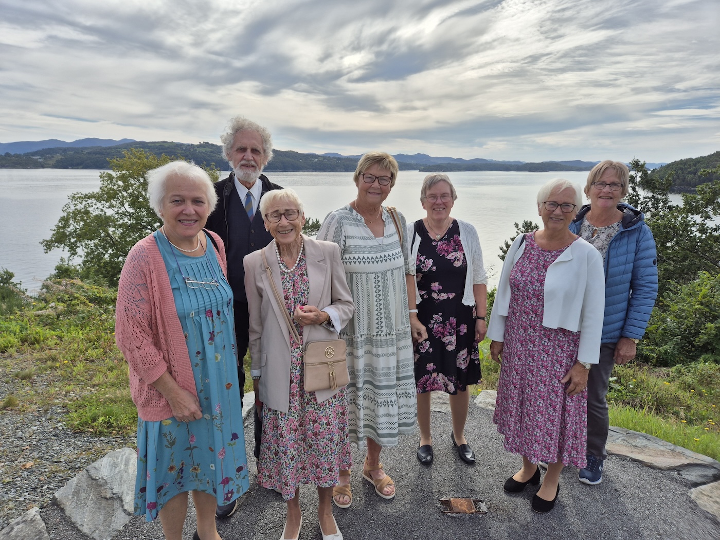 Sju personer avbildet foran en fjord