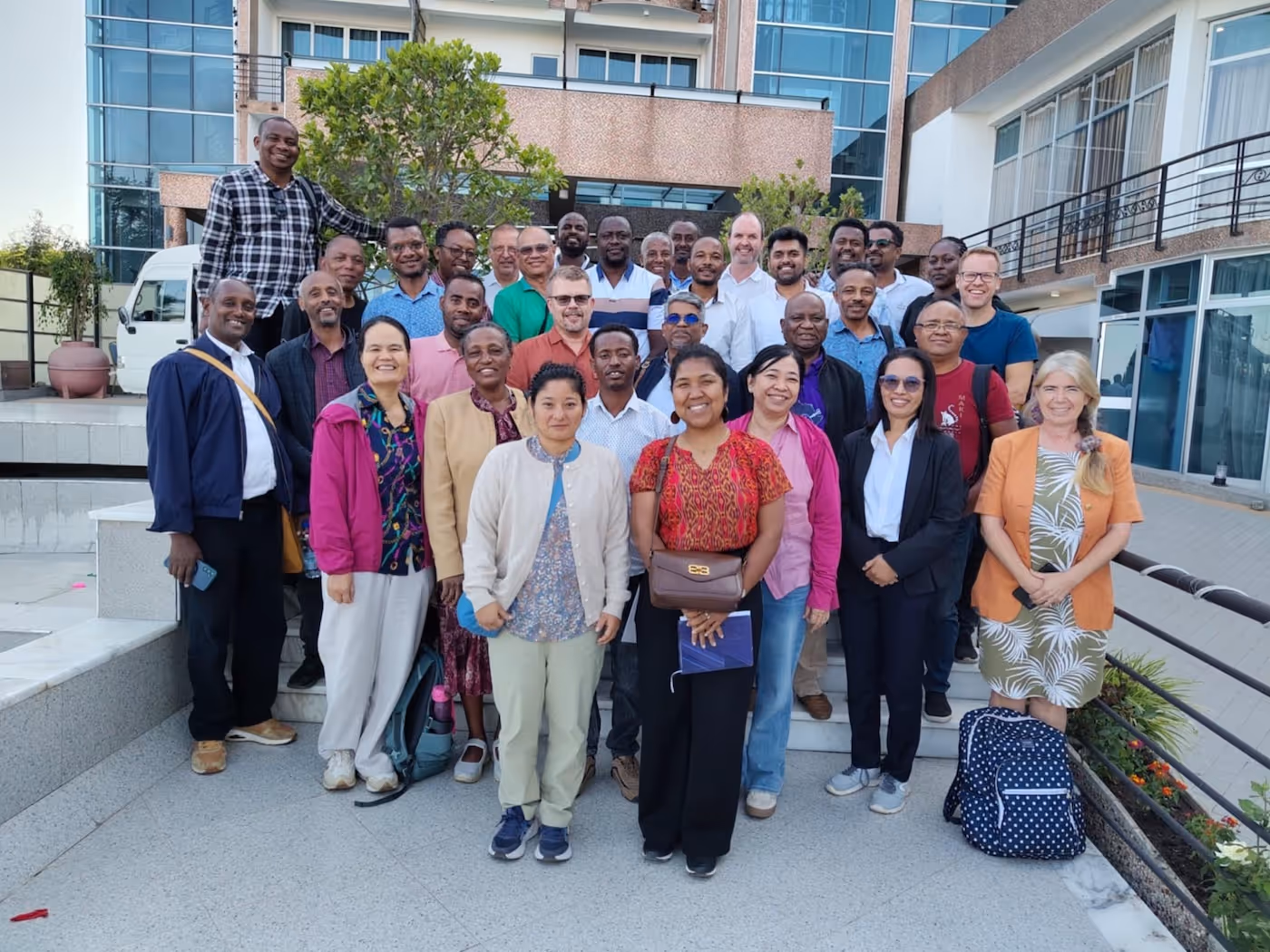 Gruppebilde av personer som står foran et bygg