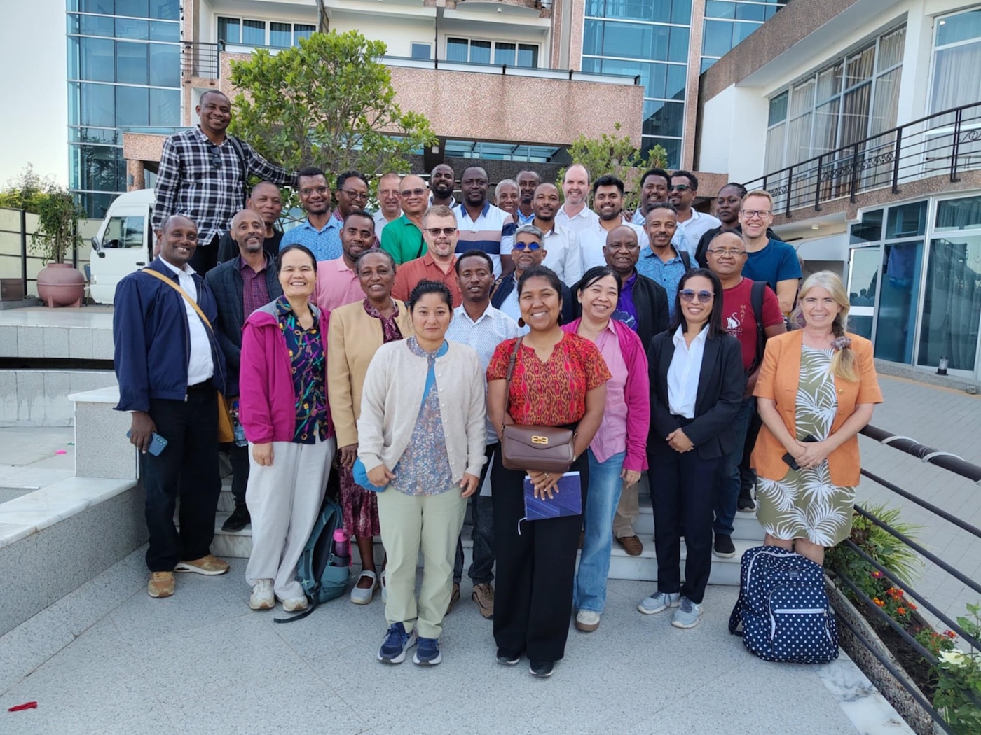 Gruppebilde av personer som står foran et bygg