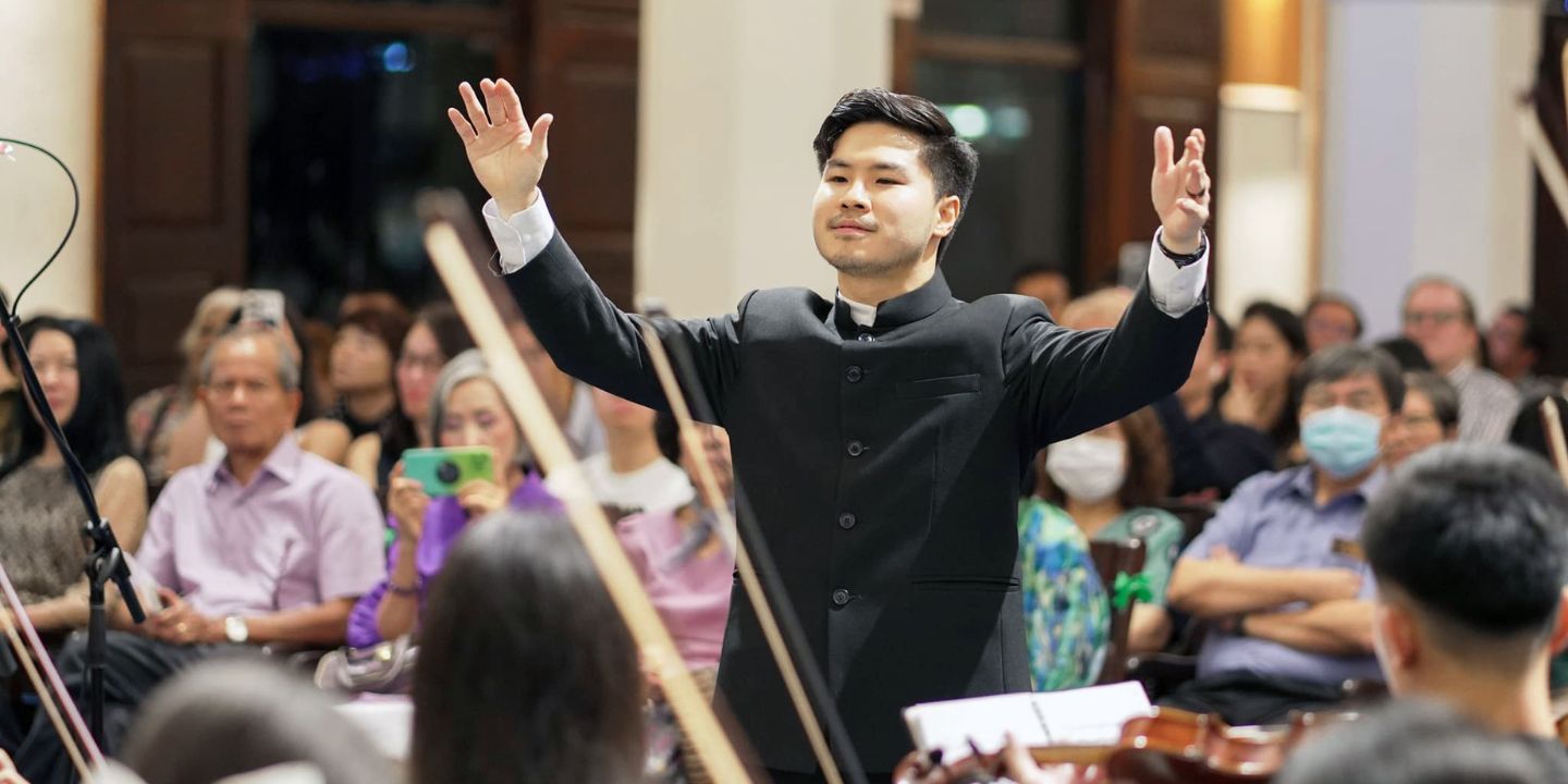 Bildet viser en dirigent som dirigerer et orkester