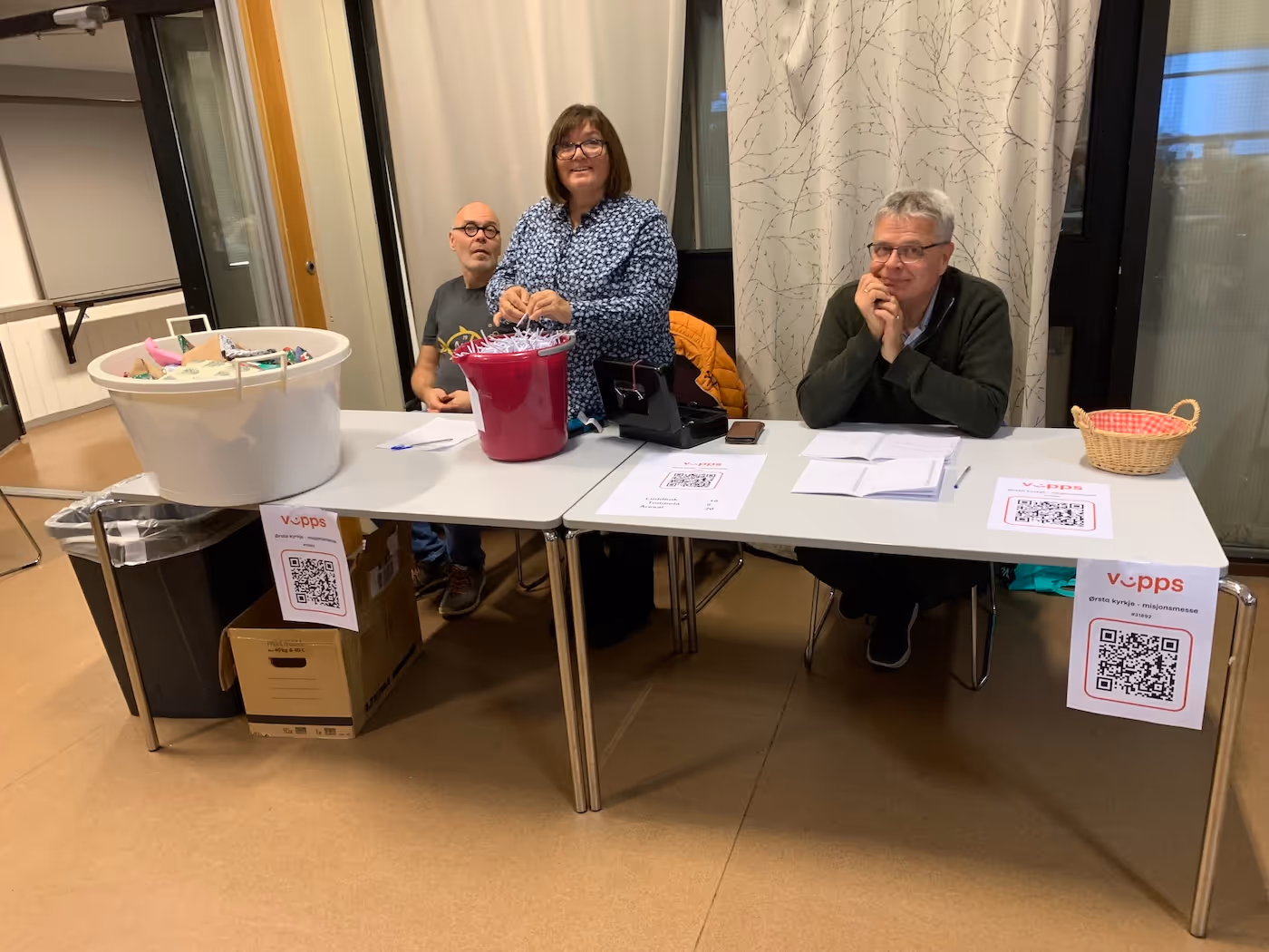 Bildet viser tre personer bak et bord