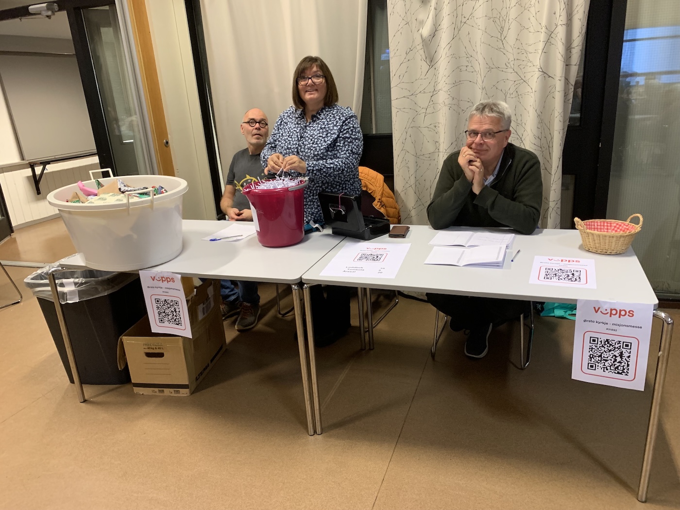 Bildet viser tre personer bak et bord