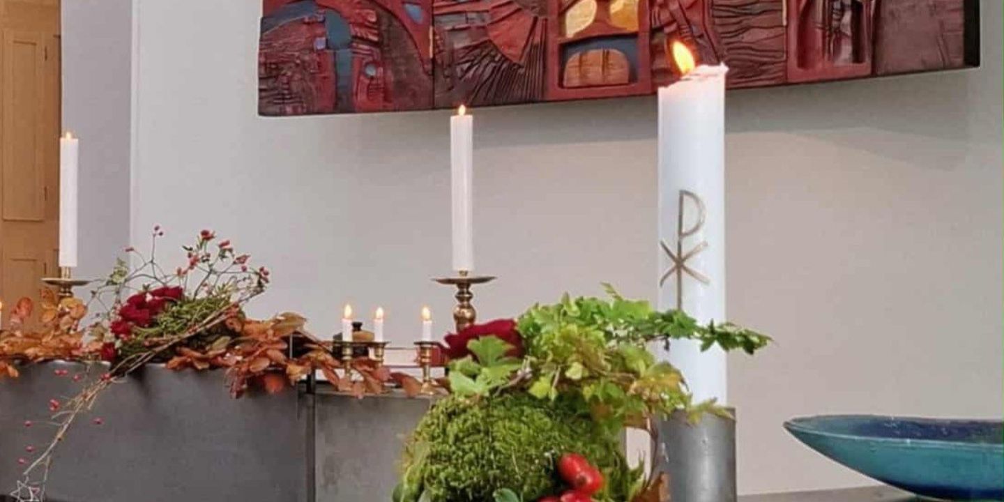 Bilder viser lys som brenner ved alteret i et kirkerom