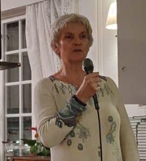 Bildet viser en dame som holder en mikrofon