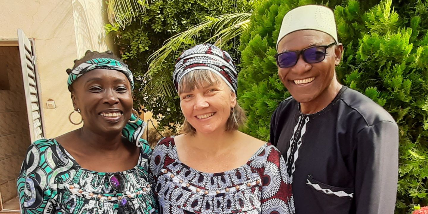 Bildet viser tre personer som smiler mot kameraet