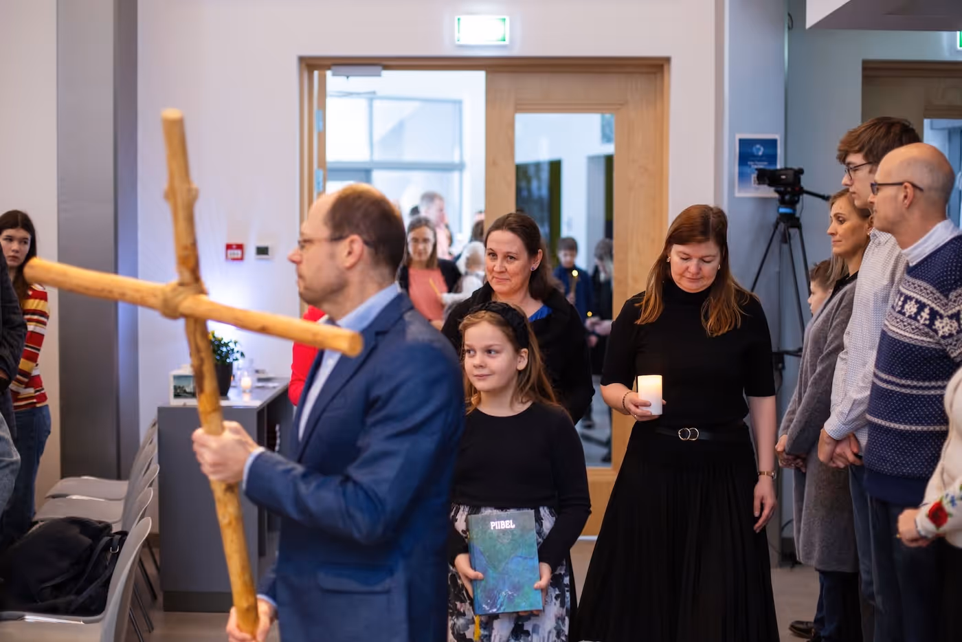 Bildet viser en prosesjon på vei inn i et kirkerom