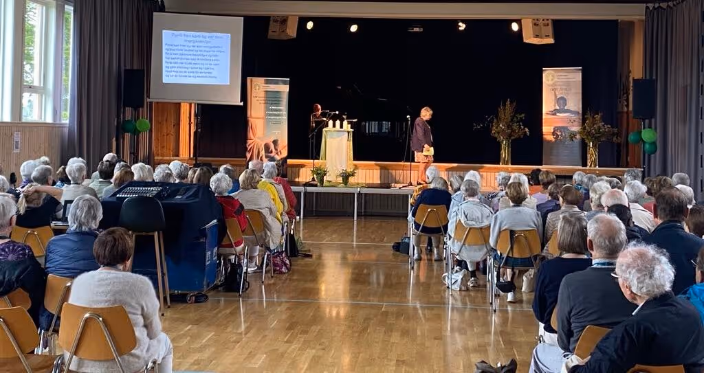 Bildet viser en forsamling foran en scene under et stevne i regi av Lærernes Misjonsforbund (LMF)