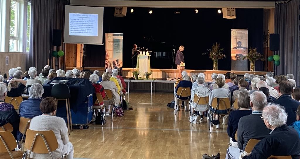 Bildet viser en forsamling foran en scene under et stevne i regi av Lærernes Misjonsforbund (LMF)