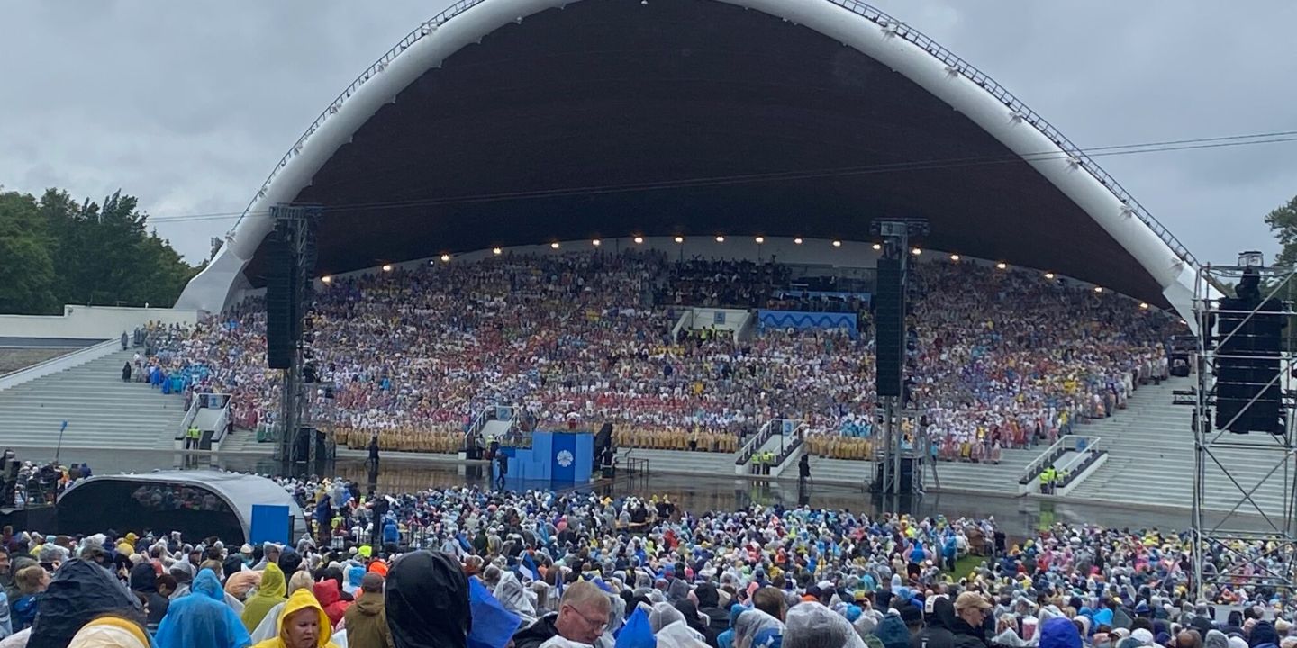 Bildet viser tusenvis av tilskuere og mange kor på en scene