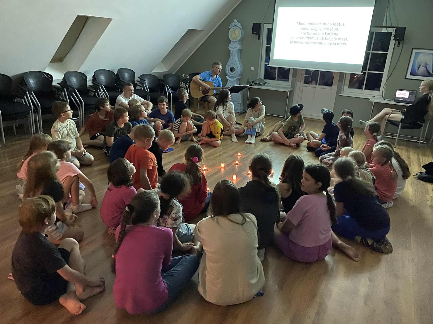 Bildet viser barn samlet til kveldsbønn