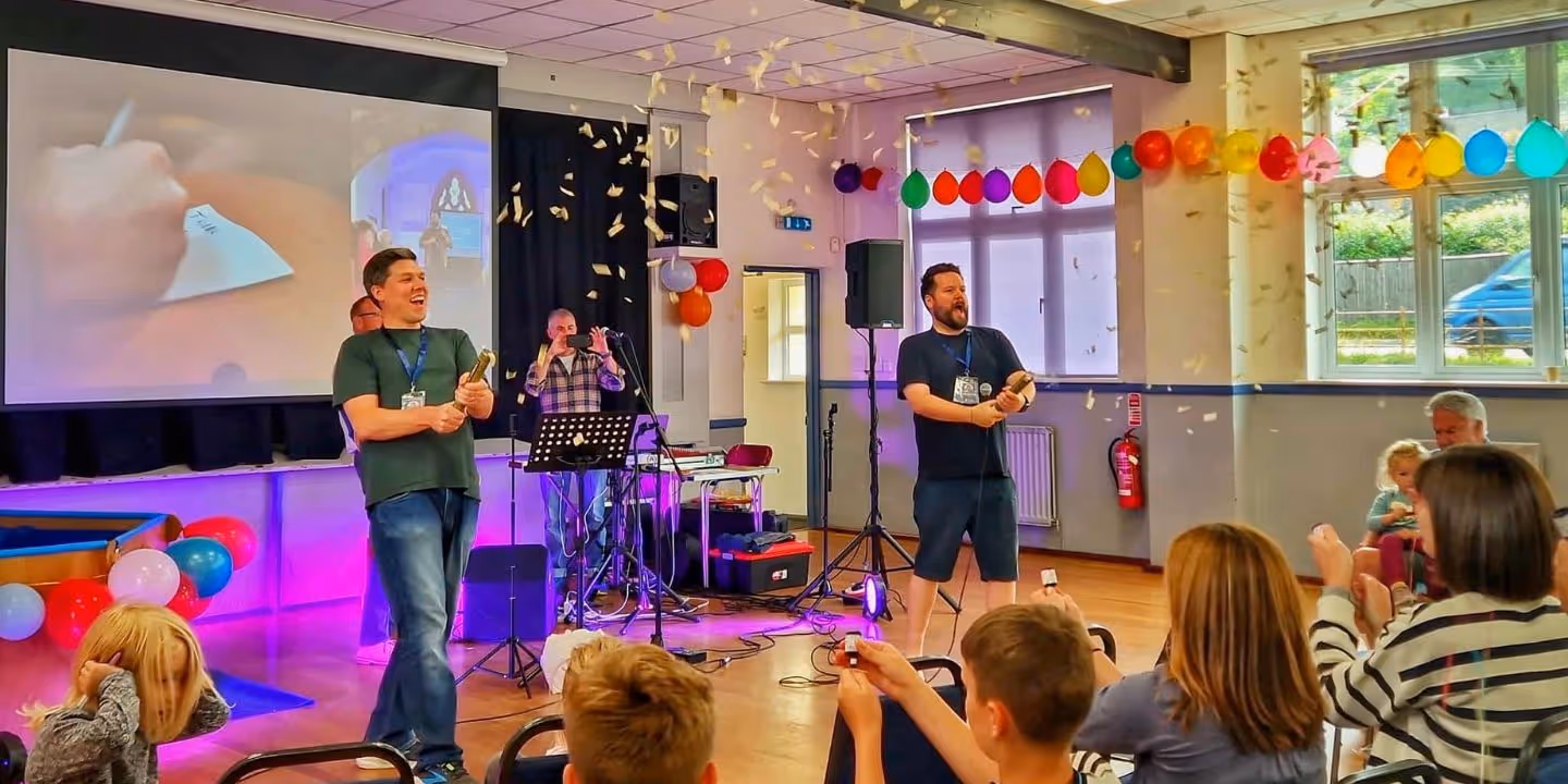 Bildet viser konfetti som sprettes ut over en forsamling i anledning St. Aidens ettårsmarkering