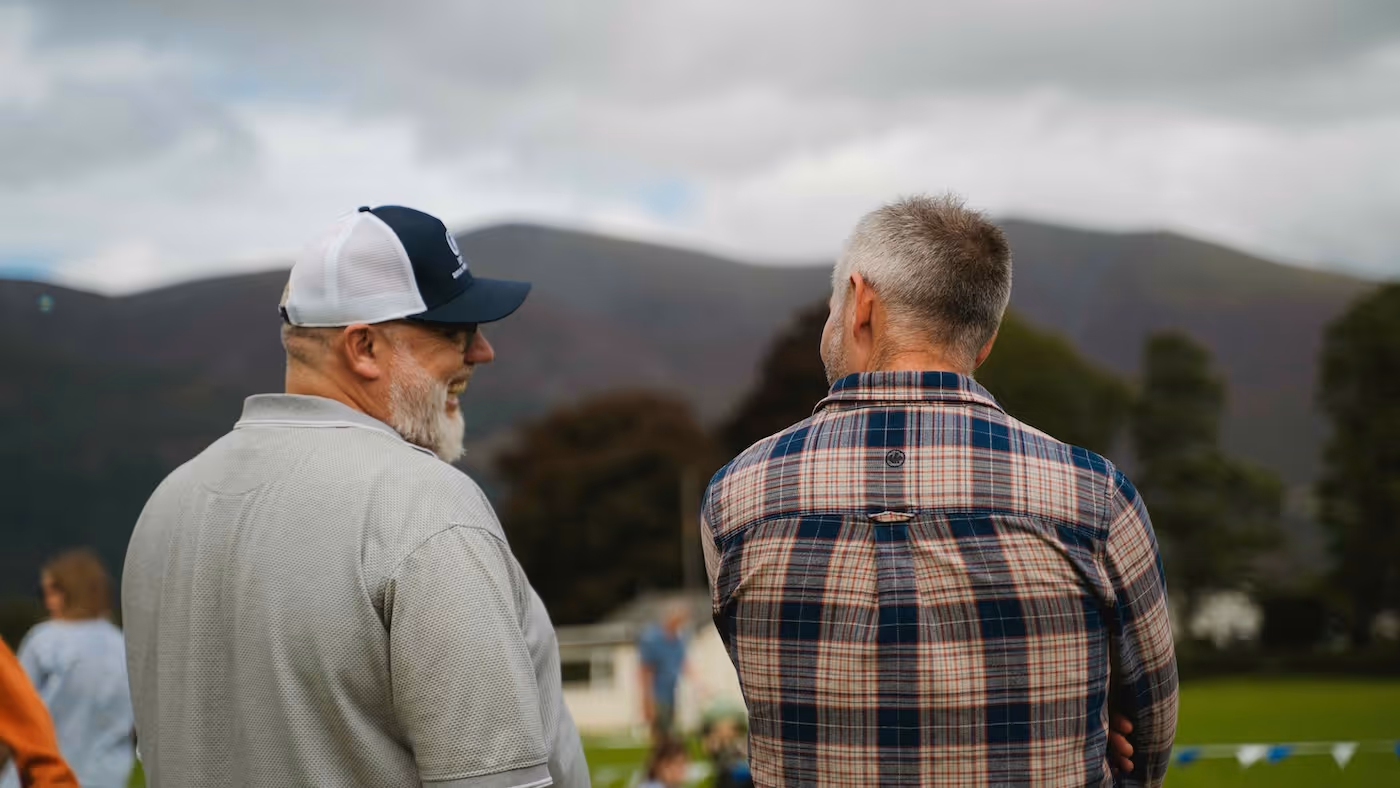 Bildet viser to menn som smiler og ler