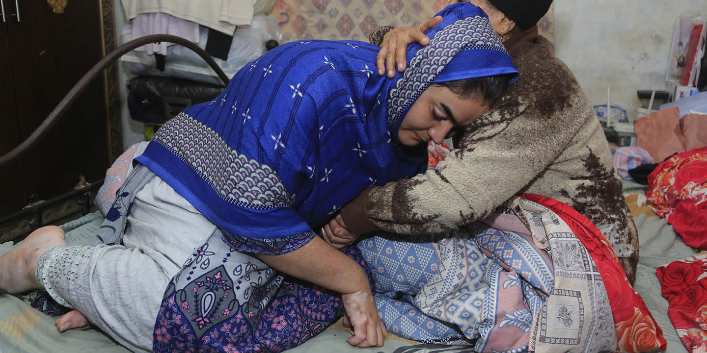 Bildet viser en dame som får trøst i fanget til en annen person