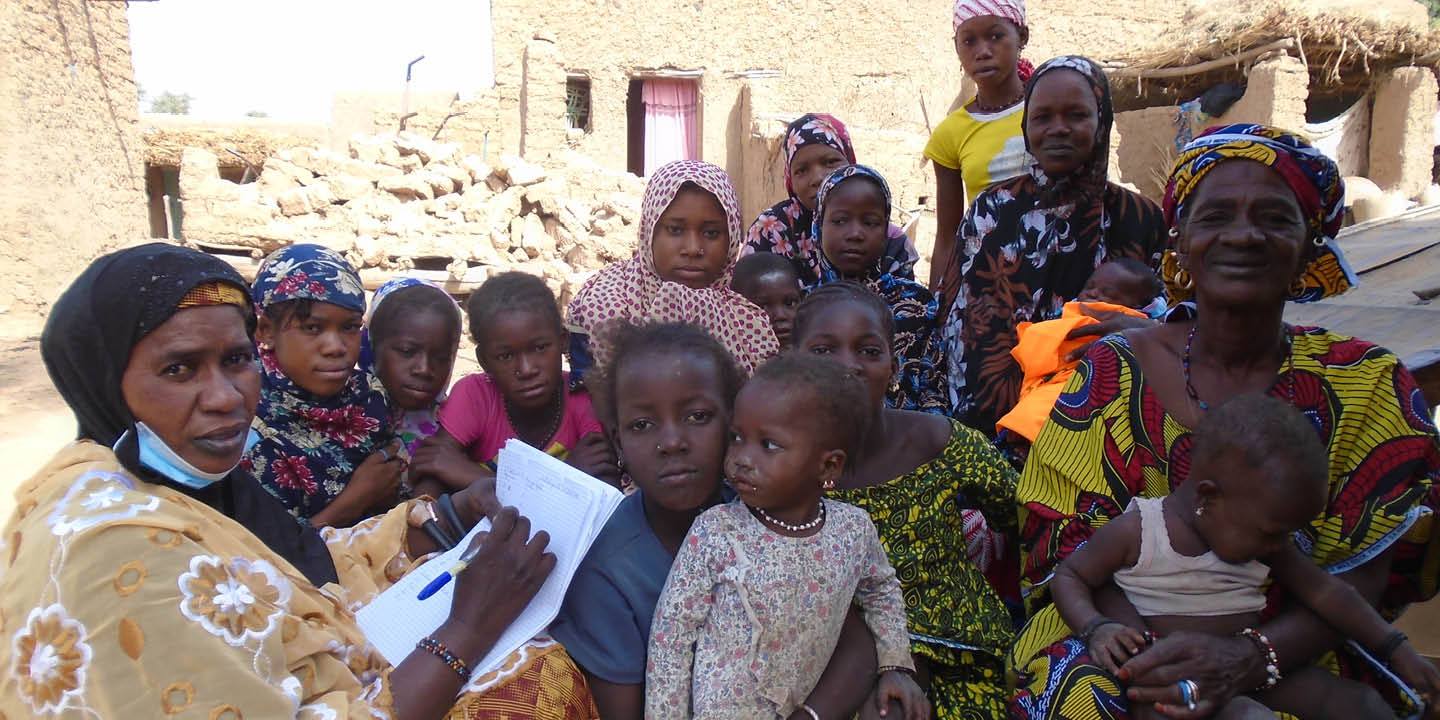 Bildet viser en forsamling med mennesker. Noen voksne, noen ungdommer og noen barn