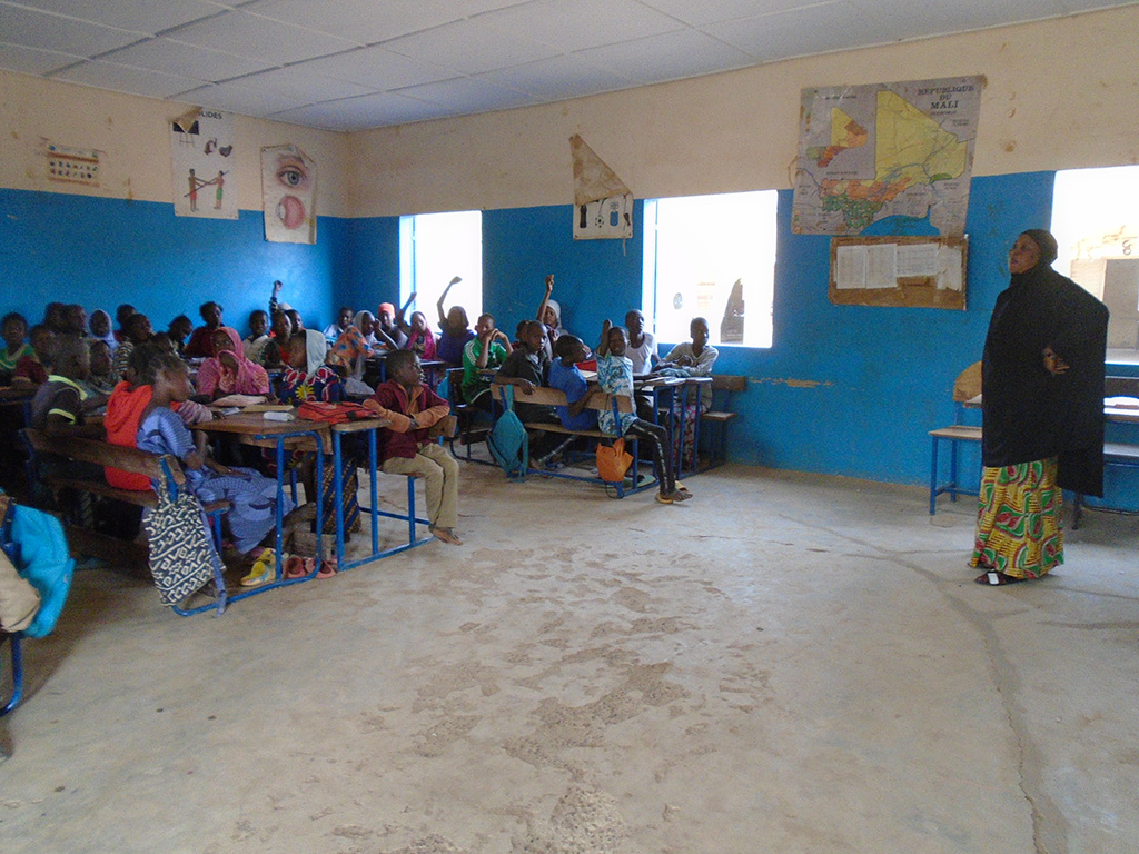 Bildet viser en skoleklasse i et klasserom som får undervisning fra en lærer