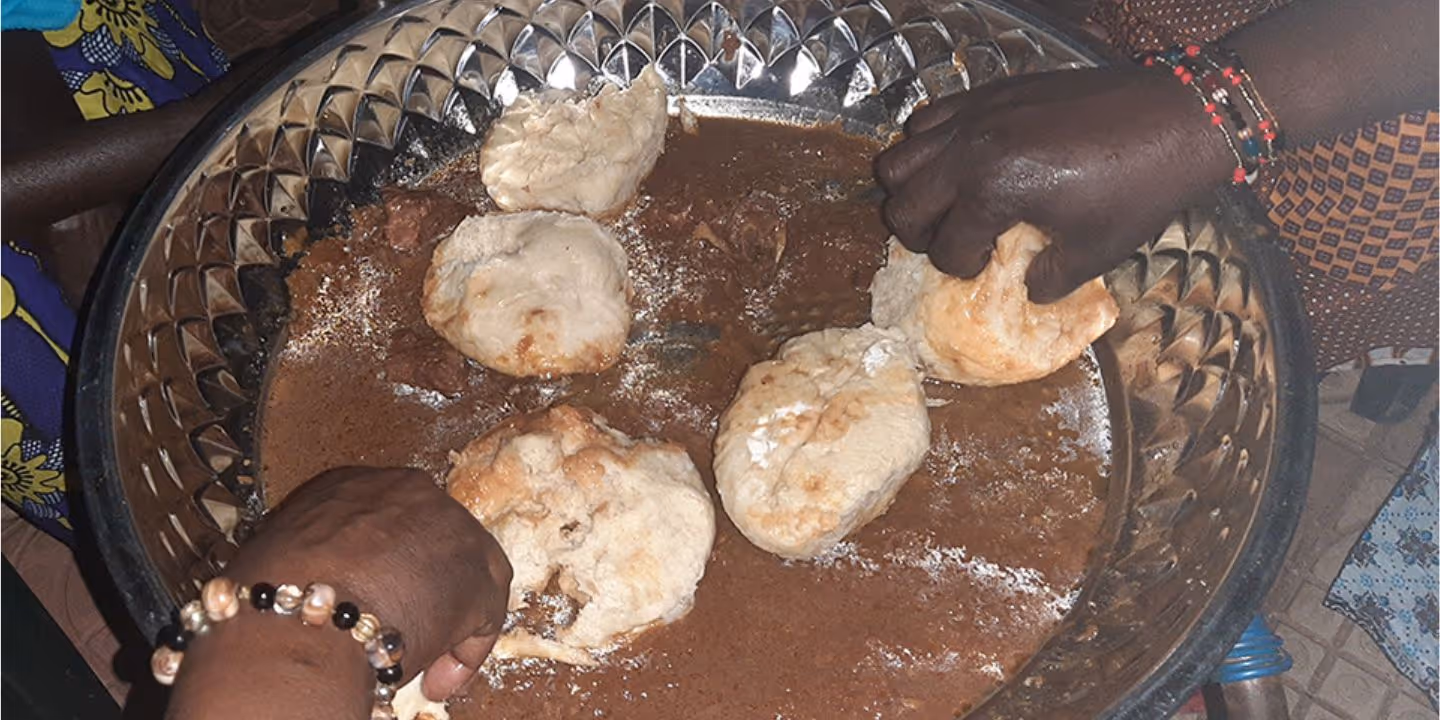 Bildet viser et nærbilde av to hender som tilbereder mat