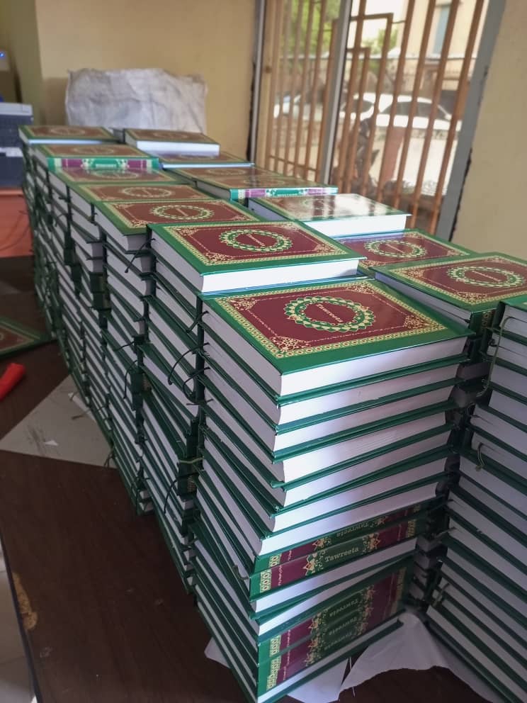 Bildet viser en stabel med bøker. Bøkene er mosebøkene, oversatt til fulani