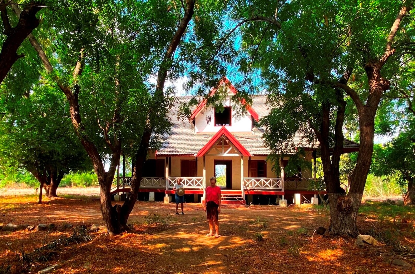 Bildet viser rektorboligen ved Tsarafototra, omgitt av grønne trær. To personer står foran bygningen