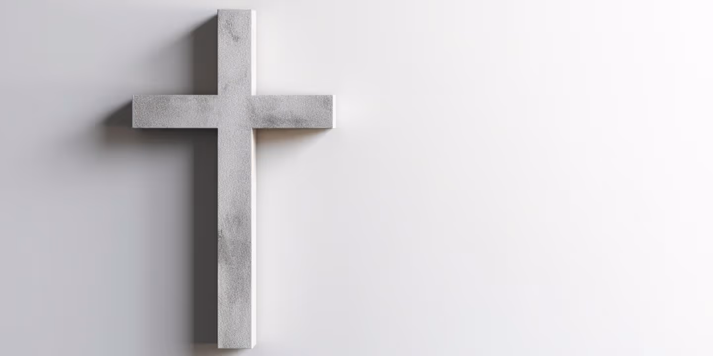Bildet viser et kors hengende på en hvit vegg