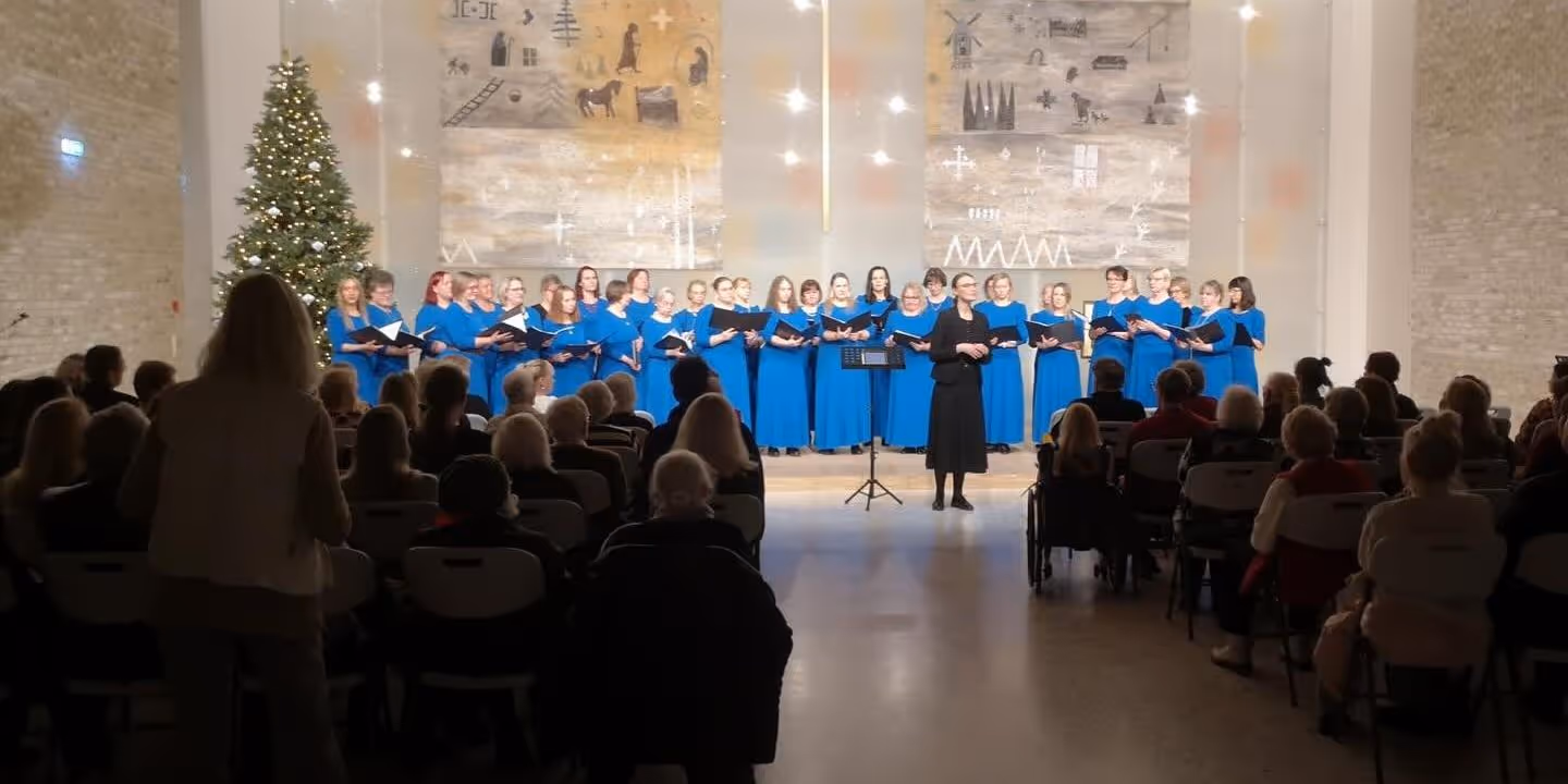 Bildet viser et kor som står framme i et kirkerom og synger