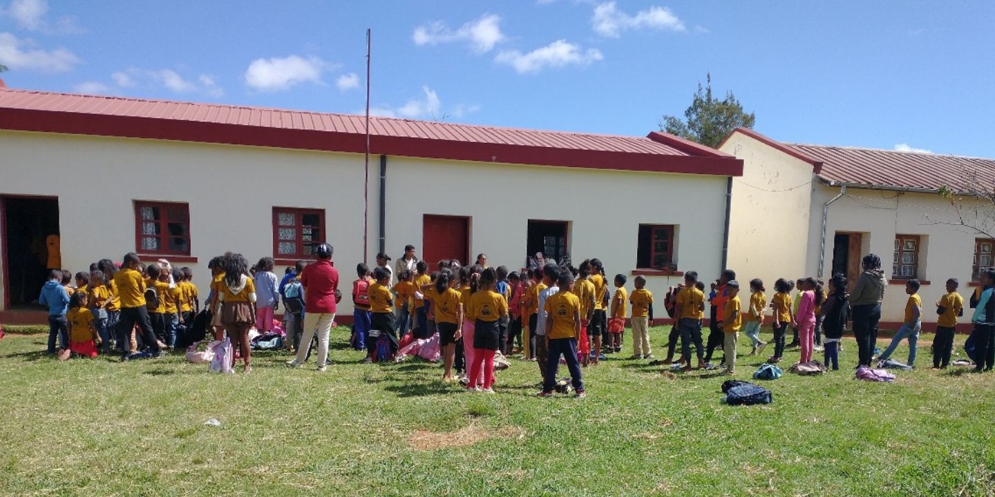 Bilder viser mange barn utenfor skolebygningen