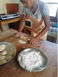 Bildet viser Rozinah idet hun kjevler ut deigen