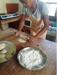 Bildet viser Rozinah idet hun kjevler ut deigen