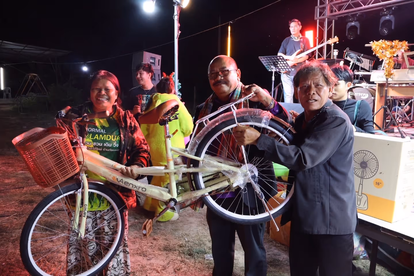 Bildet viser tre personer som viser fram en sykkel