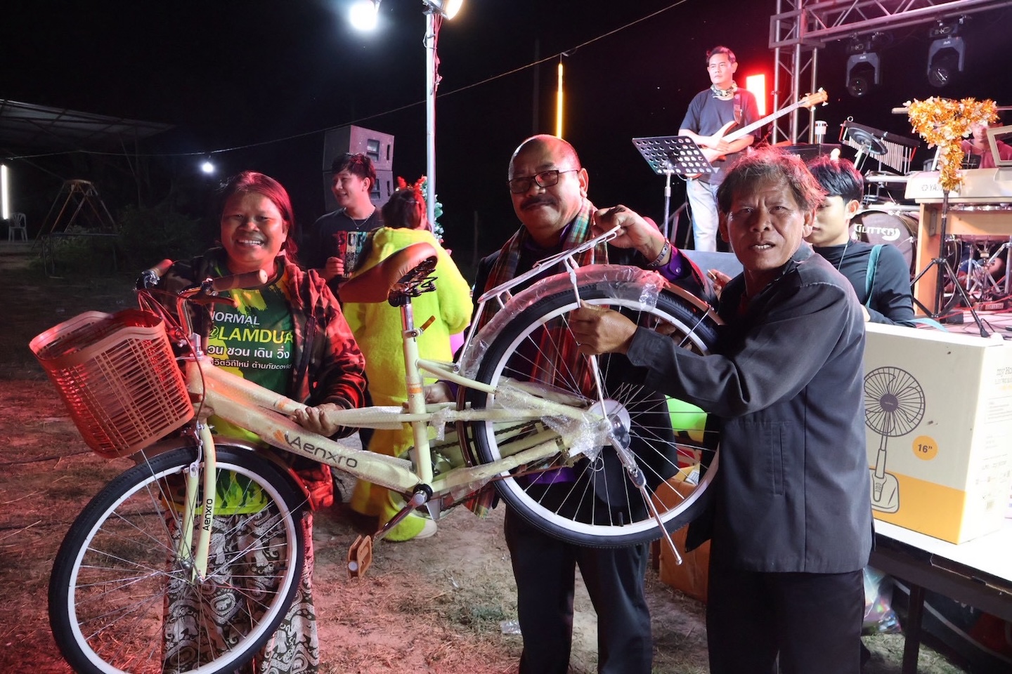 Bildet viser tre personer som viser fram en sykkel