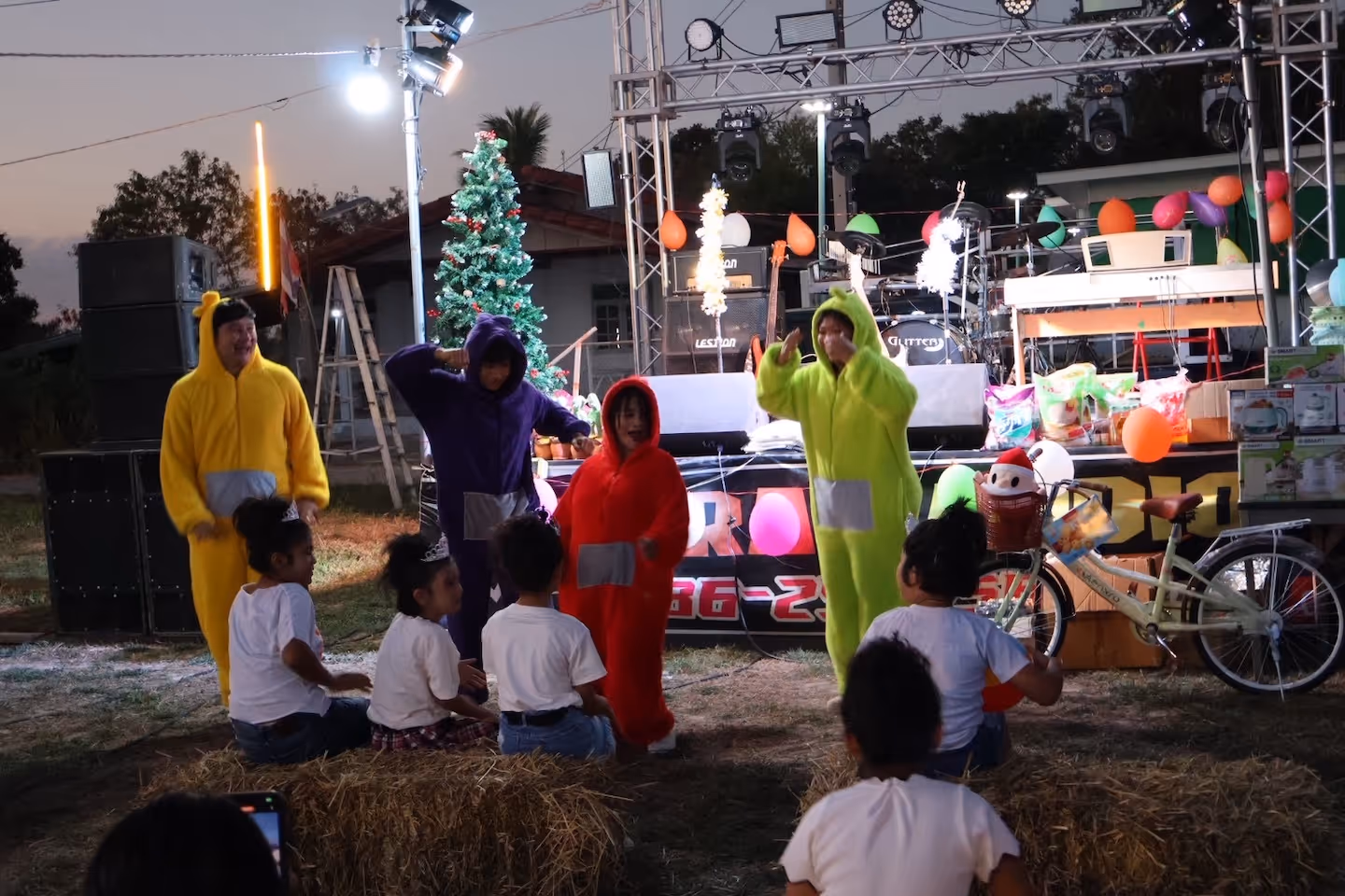 Bildet viser fire personer i teletubbie-kostymer som underholder barn