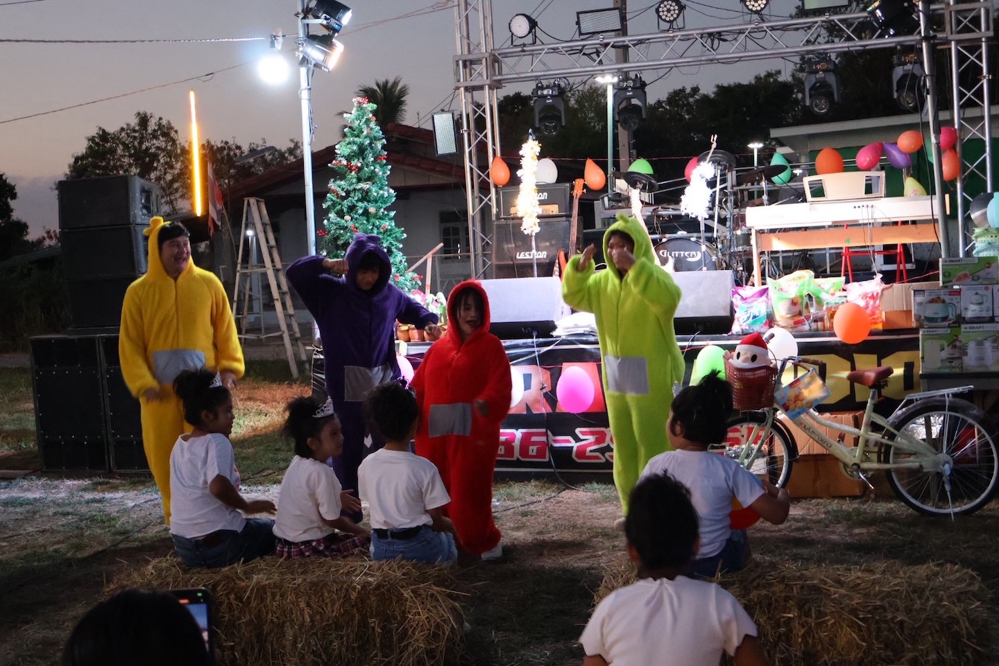 Bildet viser fire personer i teletubbie-kostymer som underholder barn