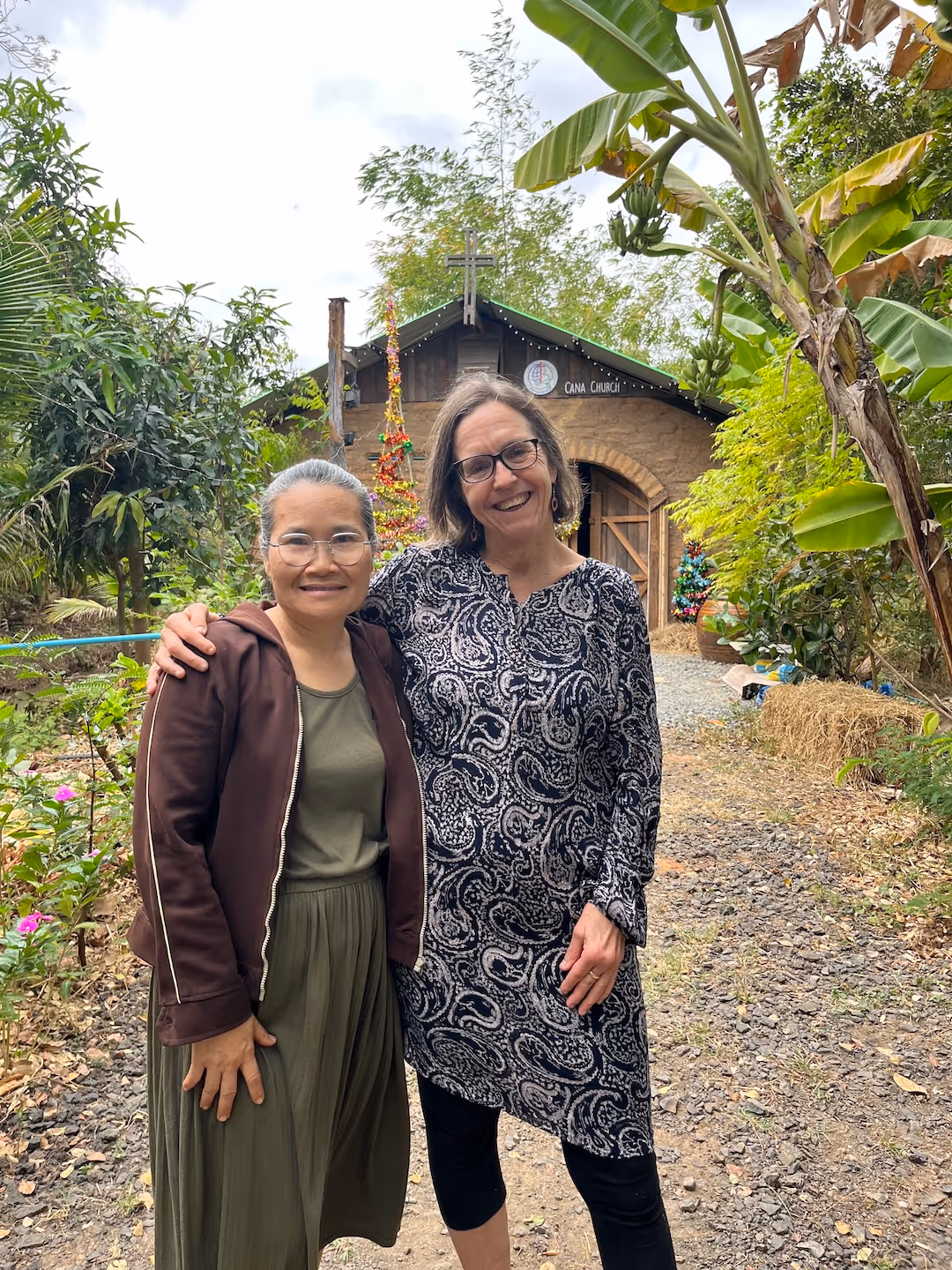 Bildet viser Anne Storstein Haug og en annen kvinne stående foran et kirkebygg med teksten «Cana church»