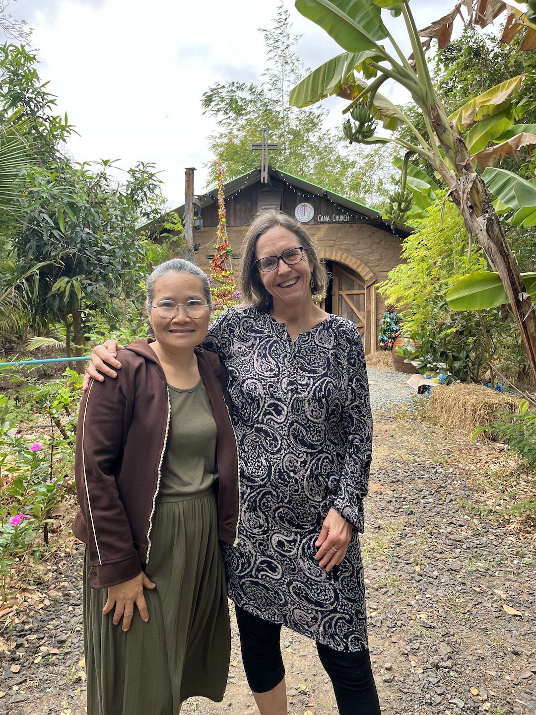 Bildet viser Anne Storstein Haug og en annen kvinne stående foran et kirkebygg med teksten «Cana church»