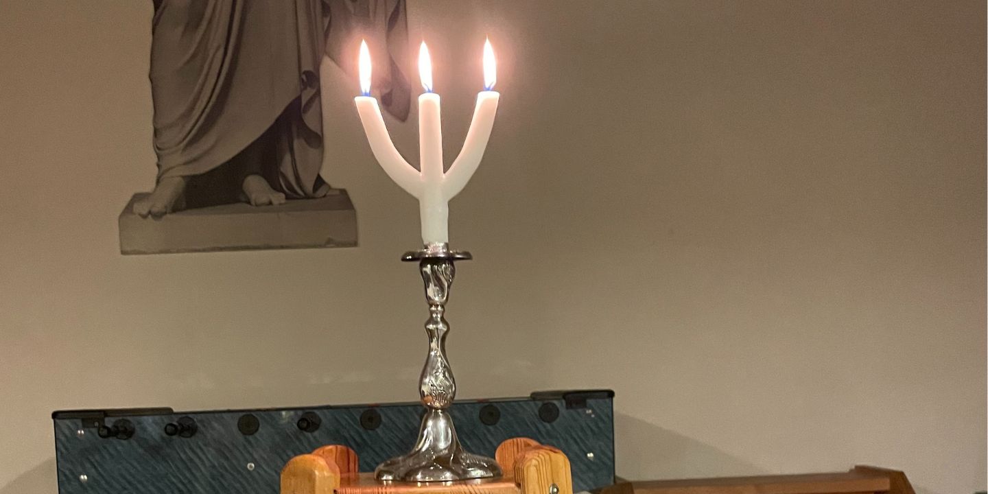 Bildet viser en lysestake med tente lys