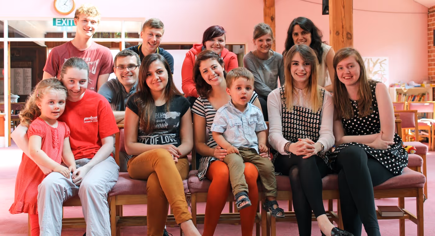 Bildet viser en gruppe barn og unge som sitter oppstilt