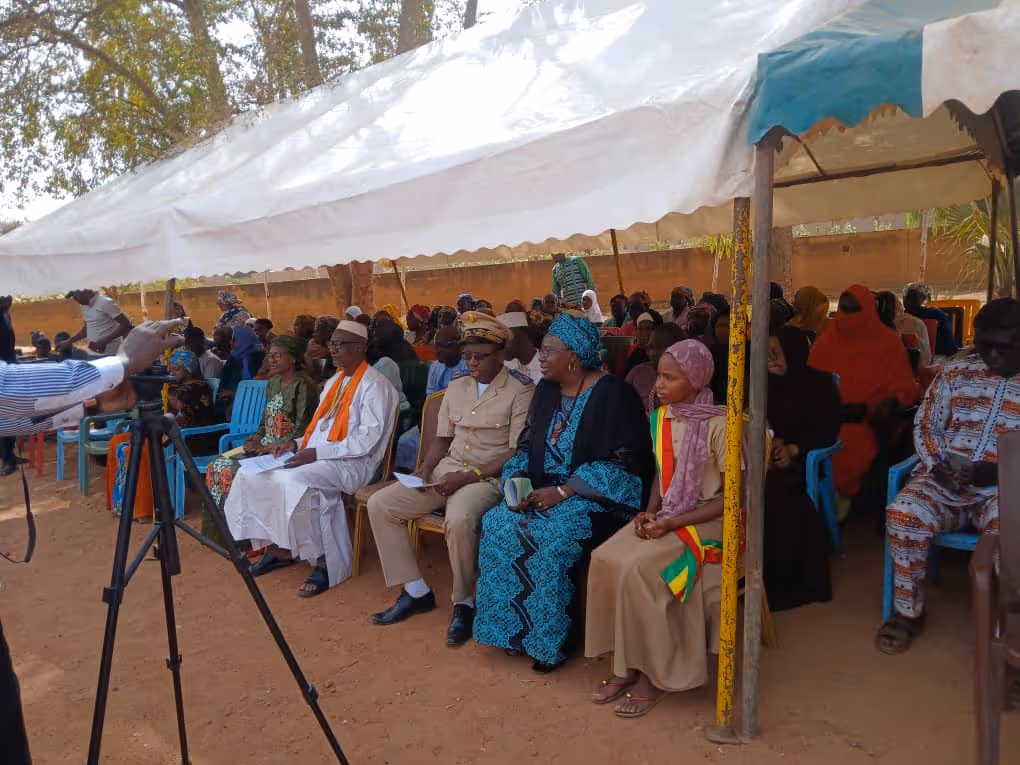 Bildet viser en forsamling festkledde mennesker som sitter under et soltelt