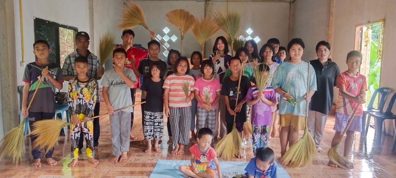 Bildet viser barn som står oppstilt og viser fram egenlagde feierkoster