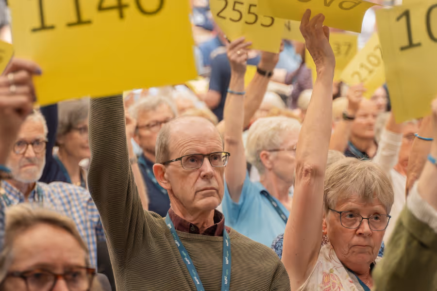 Bildet viser en delegat som avgir stemme under en avstemming