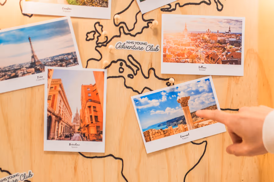 Bildet viser polaroidbilder over andre byer som henger på ei sponplate